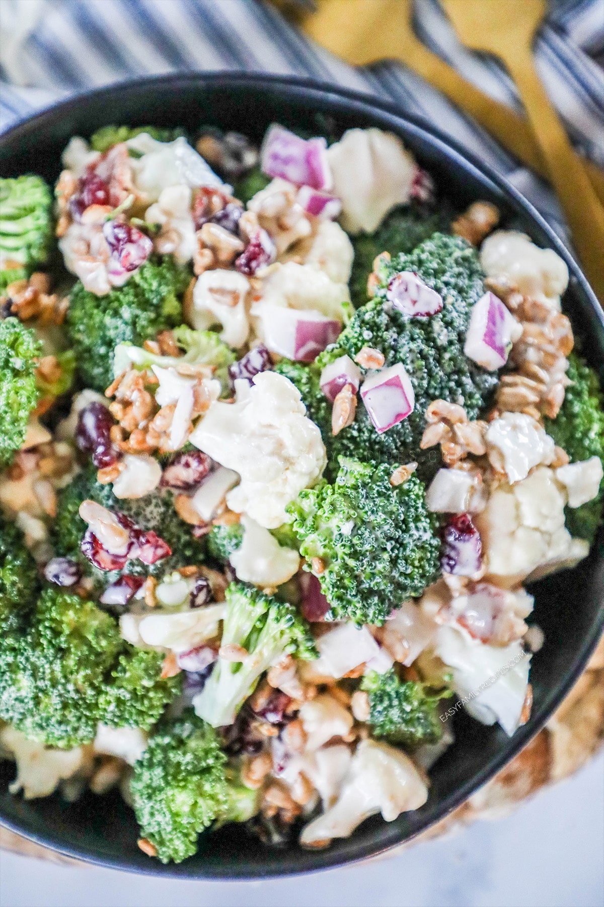 Close up shot of a bowl of broccoli cauliflower salad ready to serve for potluck.