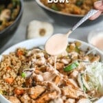 Hibachi chicken bowl served in a white bowl, with a silver spoon drizzling yum yum sauce over the top. The text reads, “Hibachi Bowls”