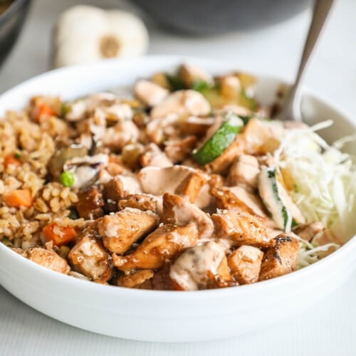 A hibachi bowl in a white bowl with a silver spoon.