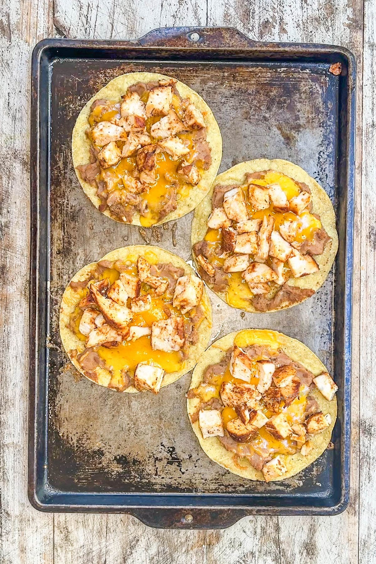 BBQ chicken tostadas on a baking sheet.