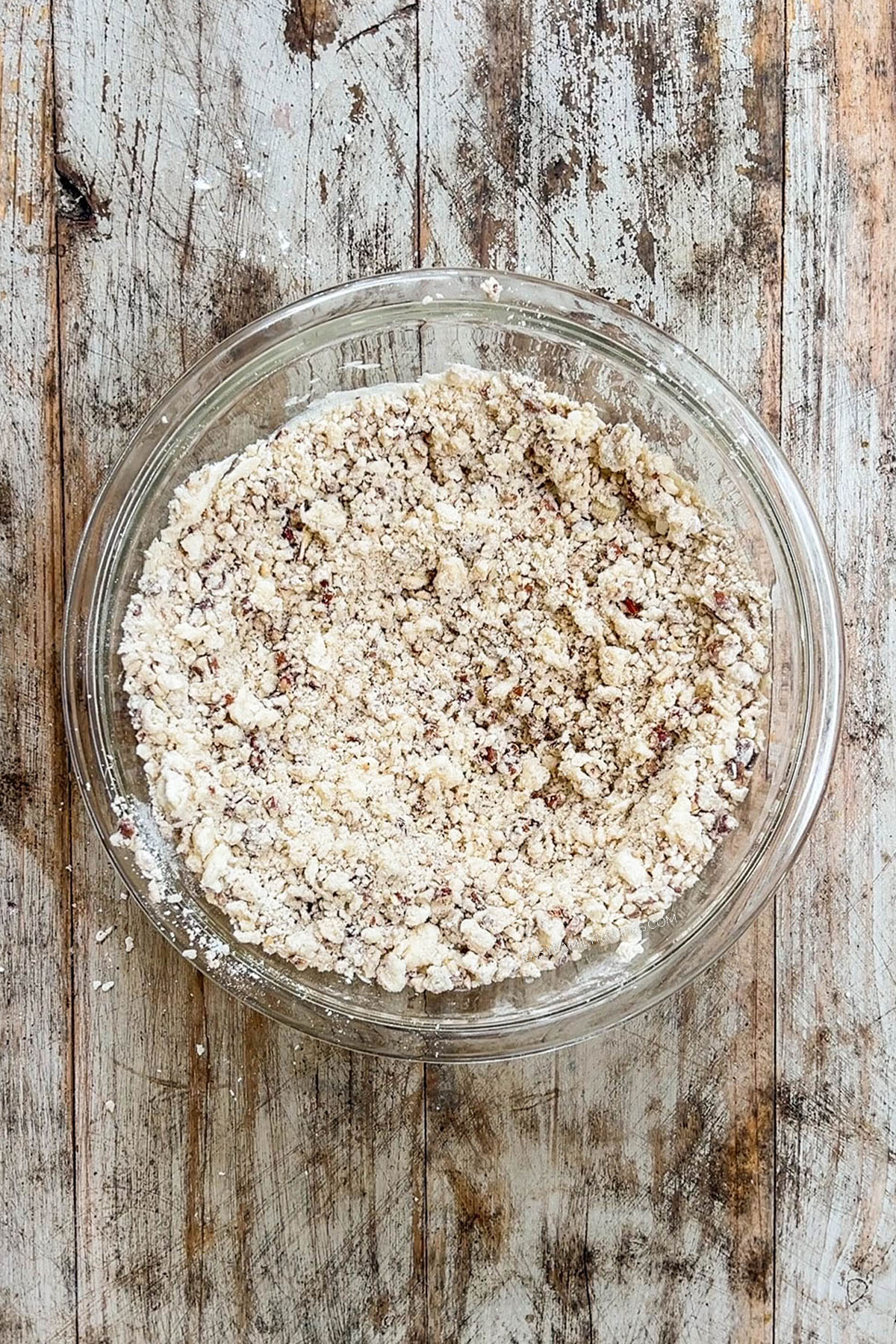 Step 4 for making cinnamon pecan snowball cookies - the batter is mixed together in a glass bowl.