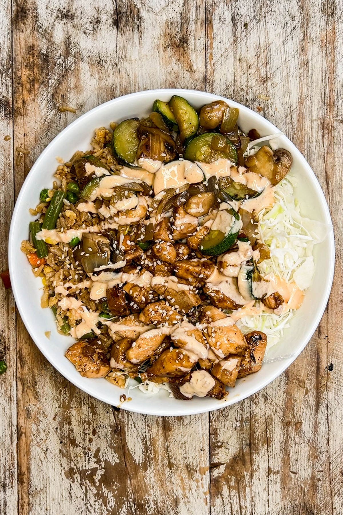 Assembled hibachi bowl in a white ceramic bowl on a distressed wood background.