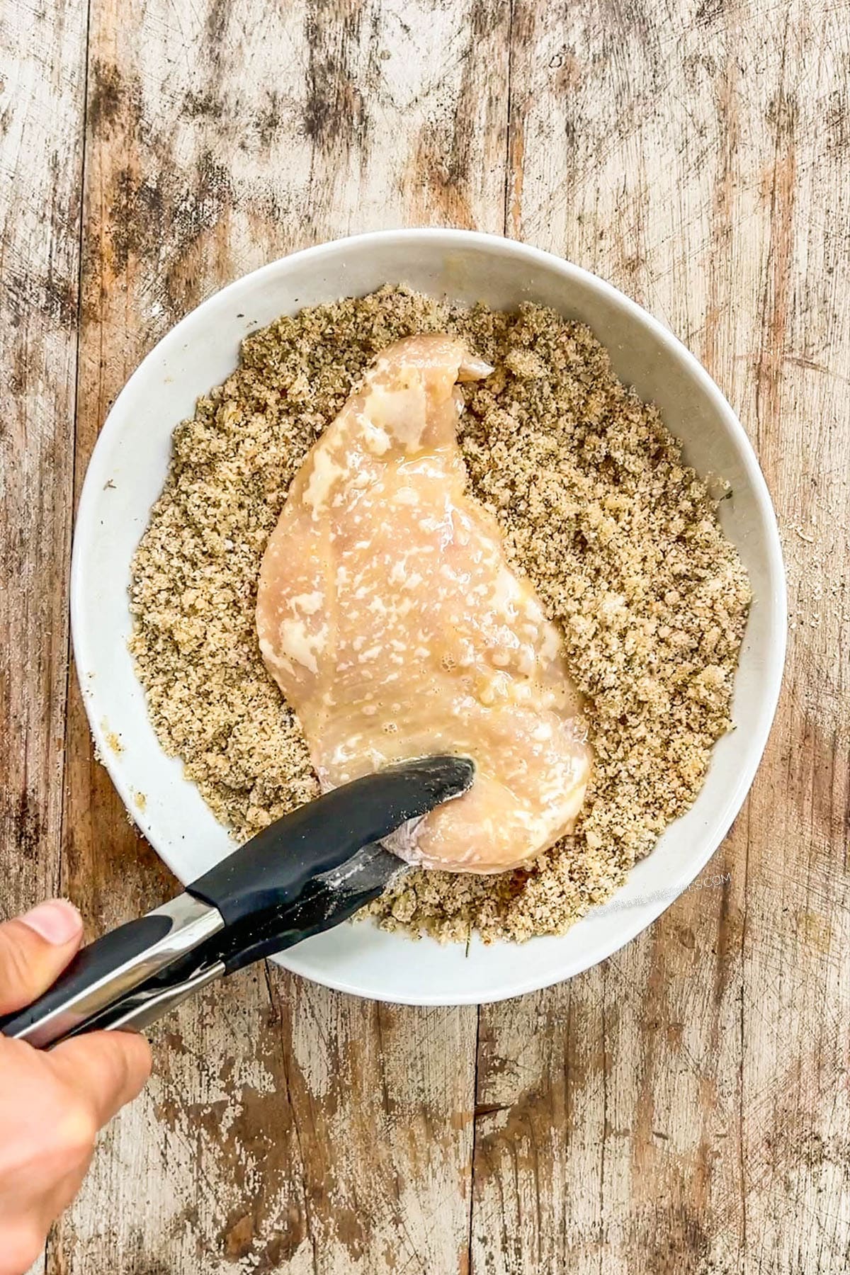 Chicken breast is dipped in a bread crumb mixture for baked chicken cutlets.