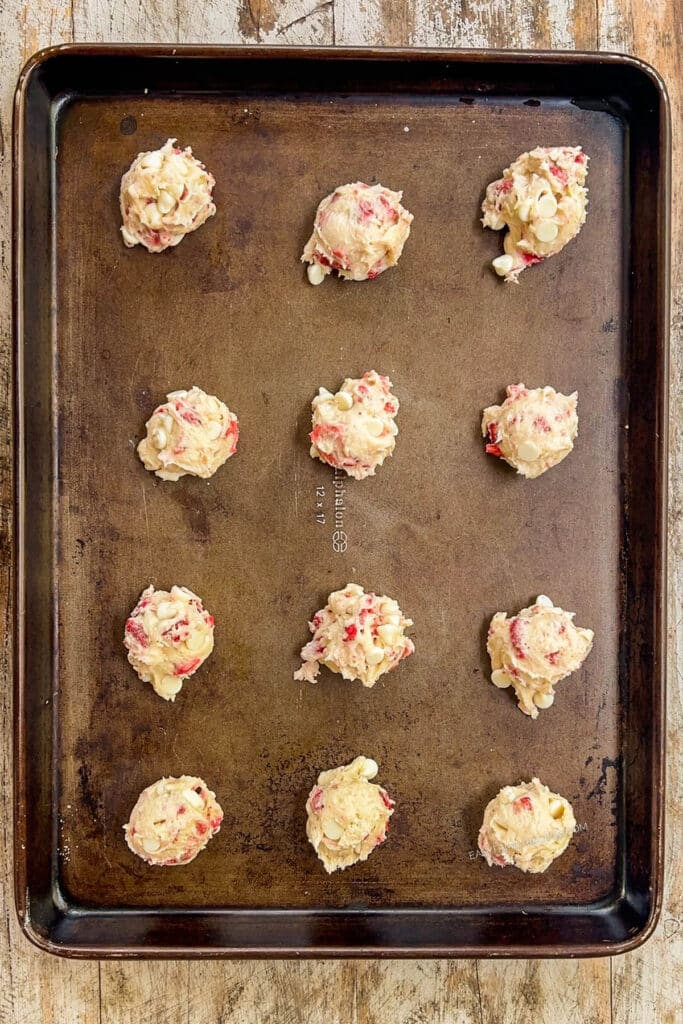 cookie dough balls on a baking sheet.