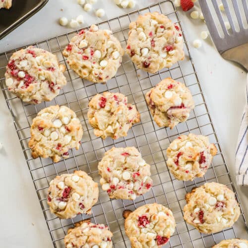 above image of a batch of raspberry white chocolate cookies on a cooling rack.