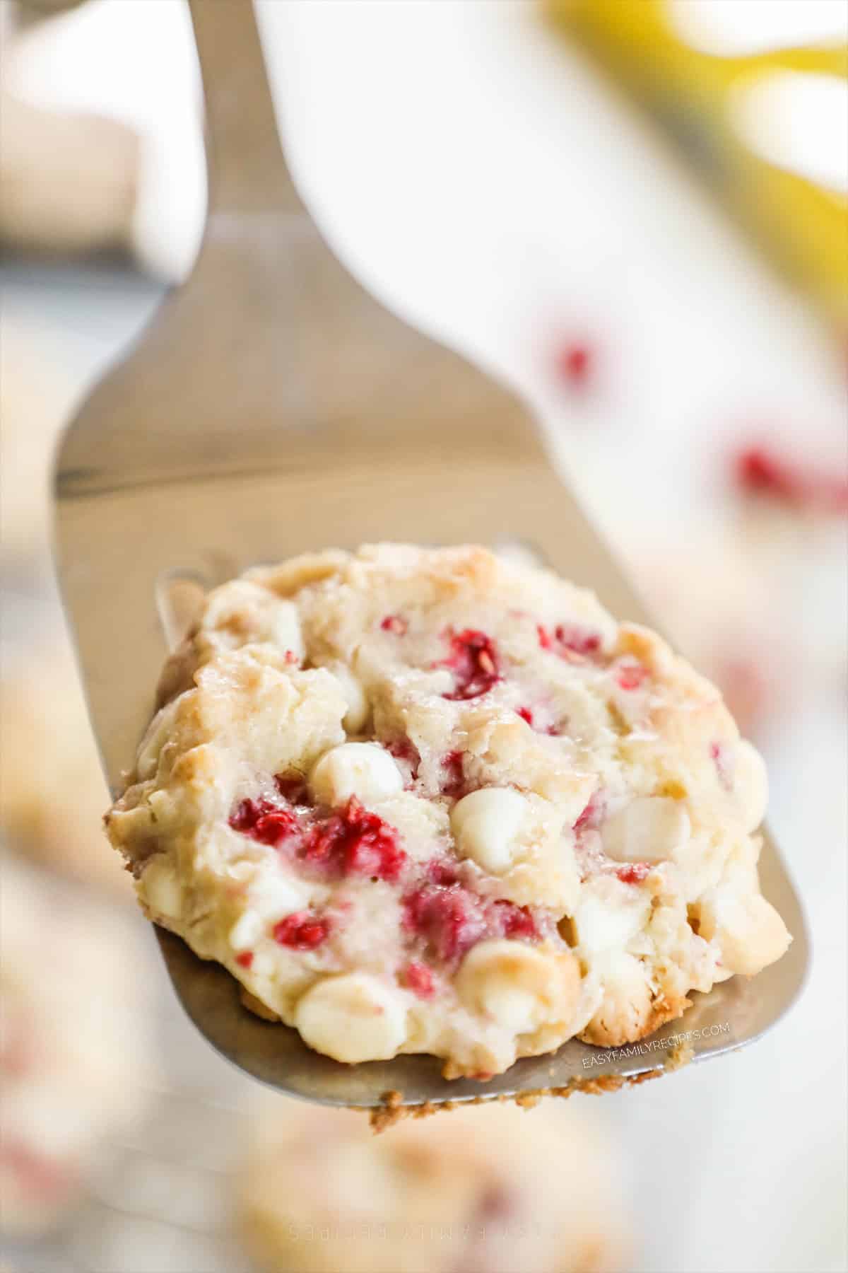 a raspberry cheesecake cookie held on a spatula. 