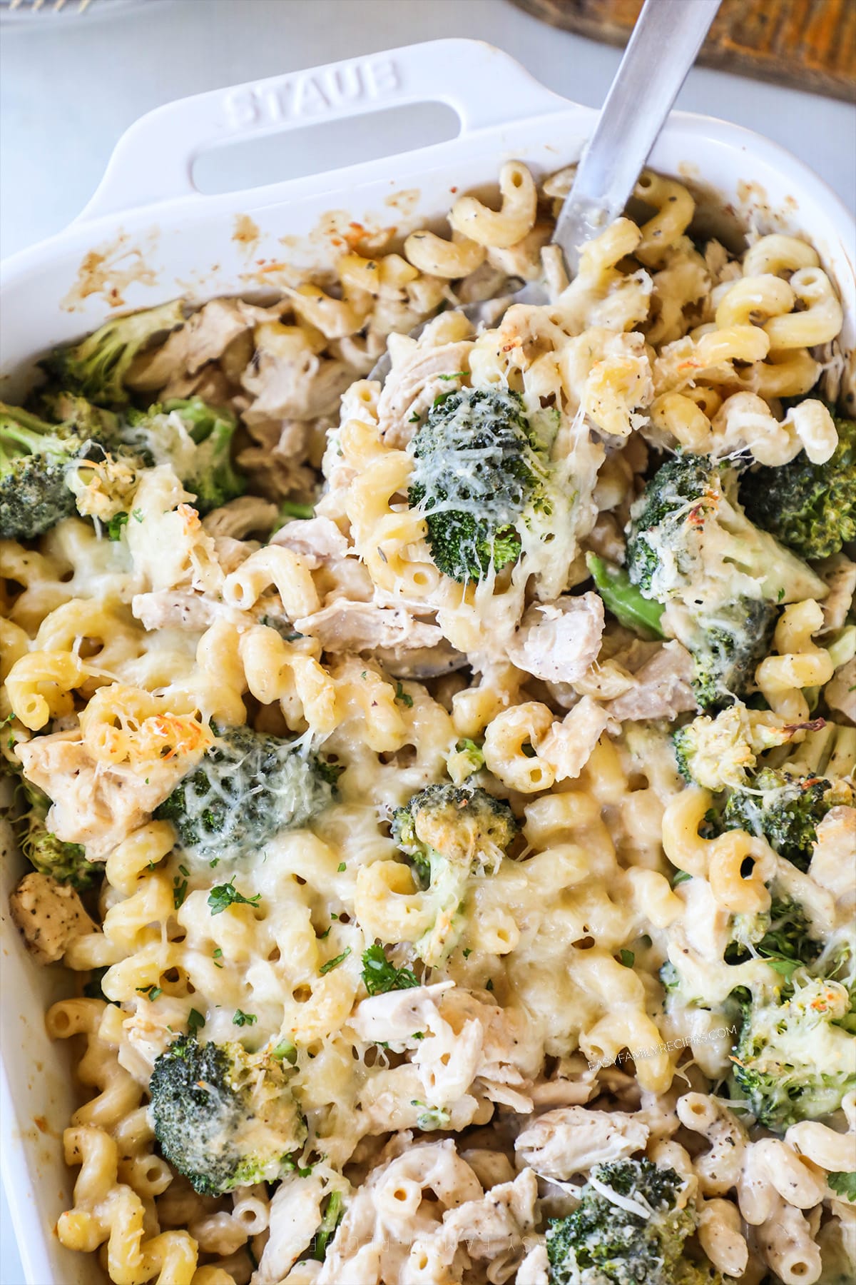 above image of baked broccoli alfredo pasta in a casserole dish.