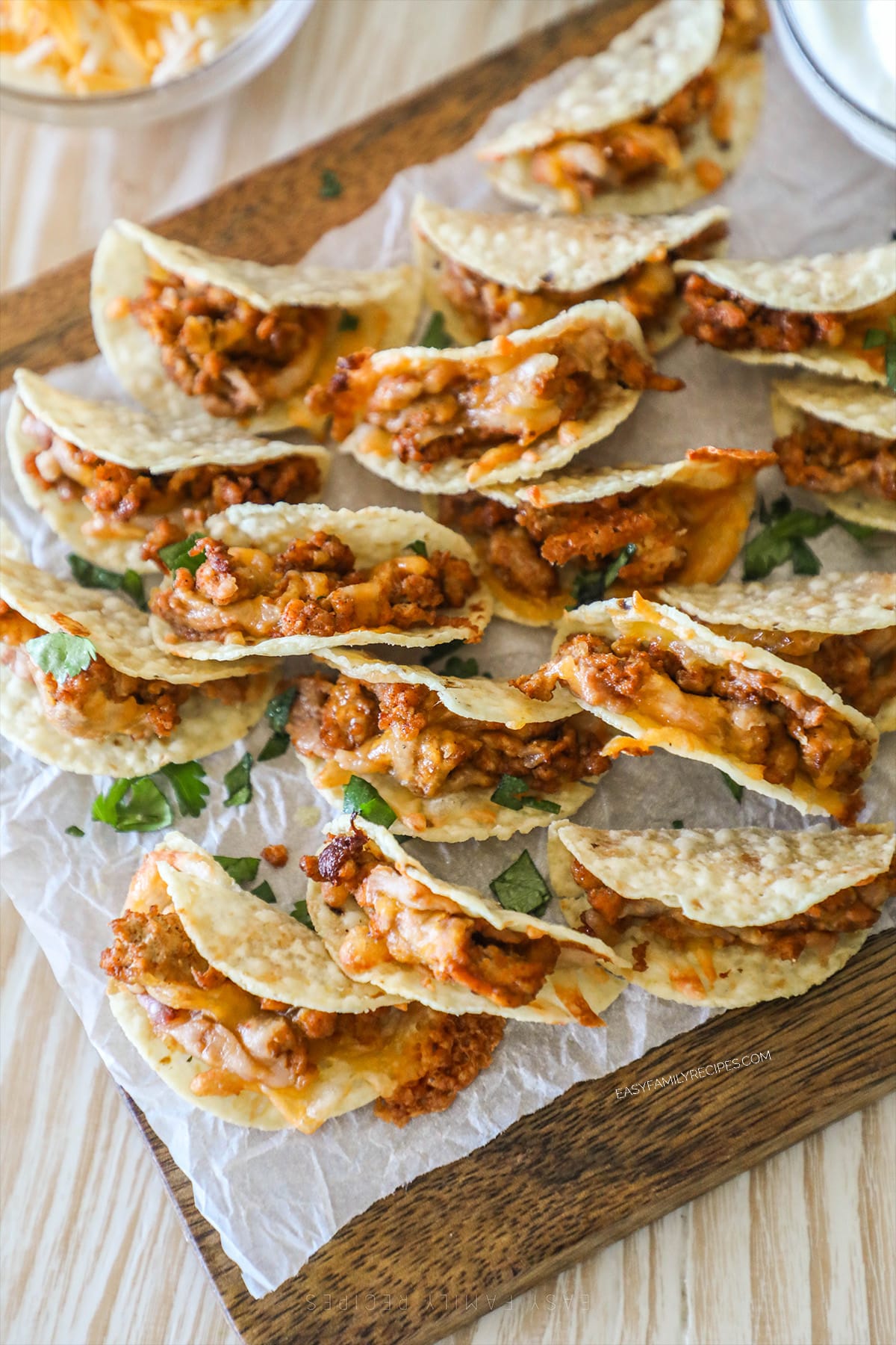 Tiny Tacos on a parchment-lined wooden board.