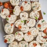 A top view of a cutting board topped with chicken bacon ranch pinwheels. The text reads, "Chicken Bacon Ranch Pinwheels"