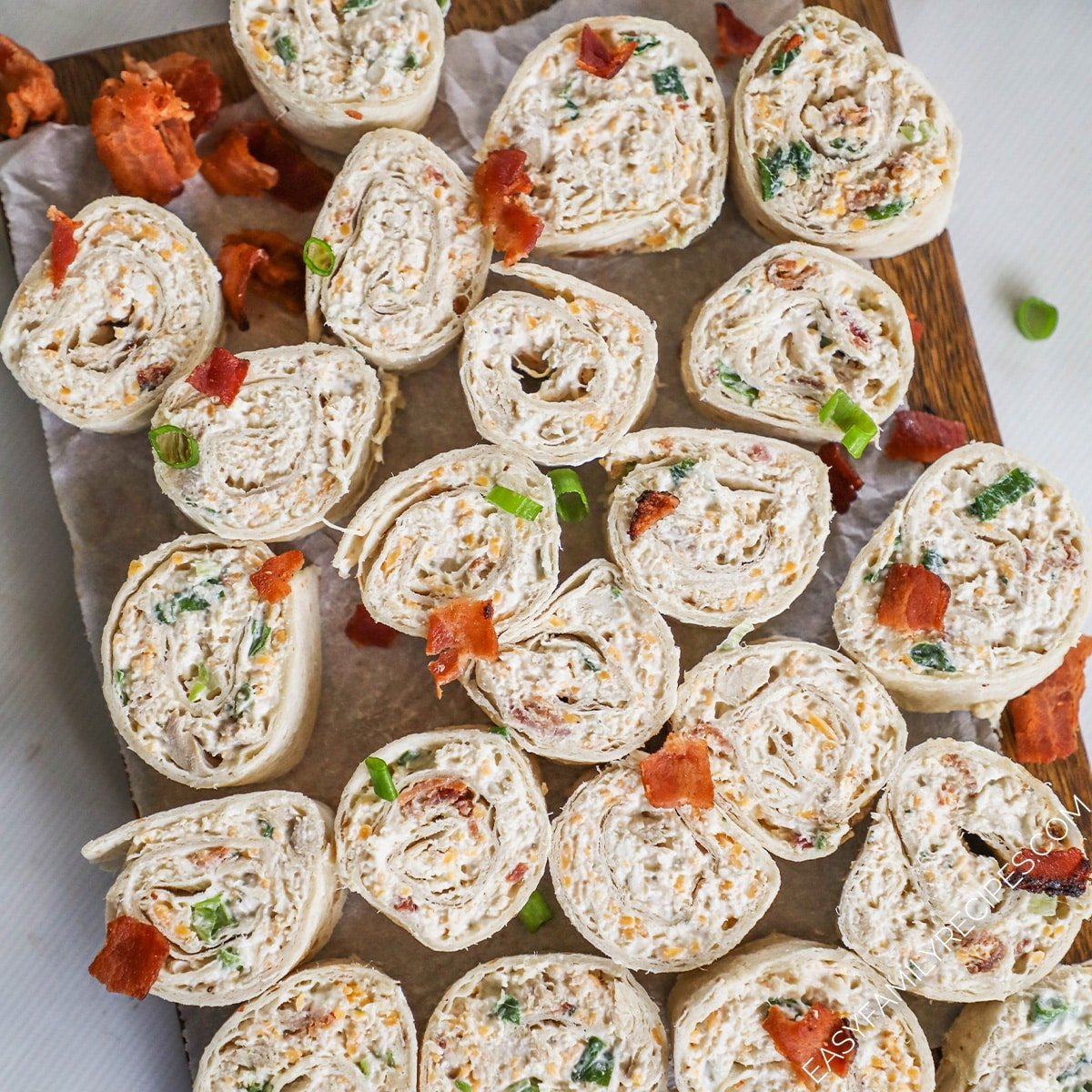 A top view of a cutting board topped with chicken bacon ranch pinwheels.