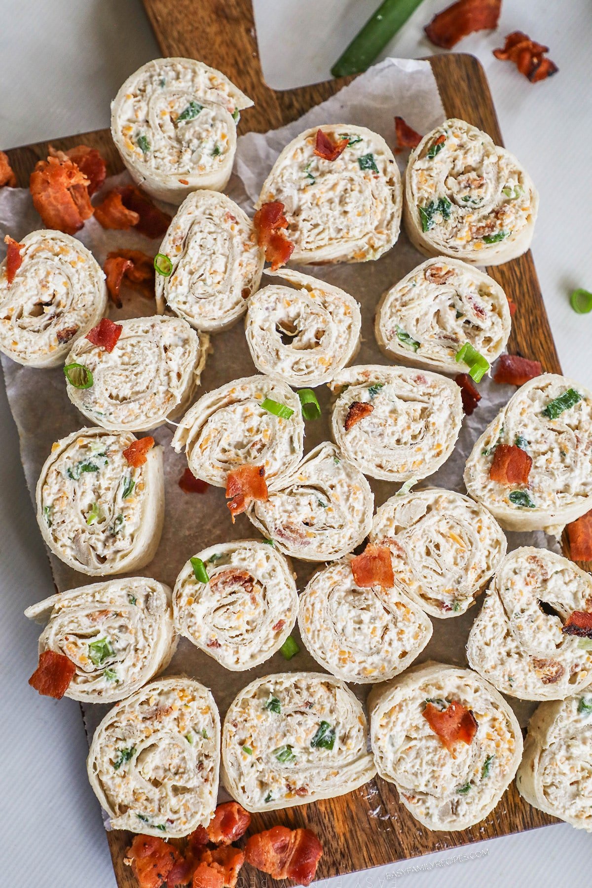 A top view of a cutting board topped with chicken bacon ranch pinwheels.