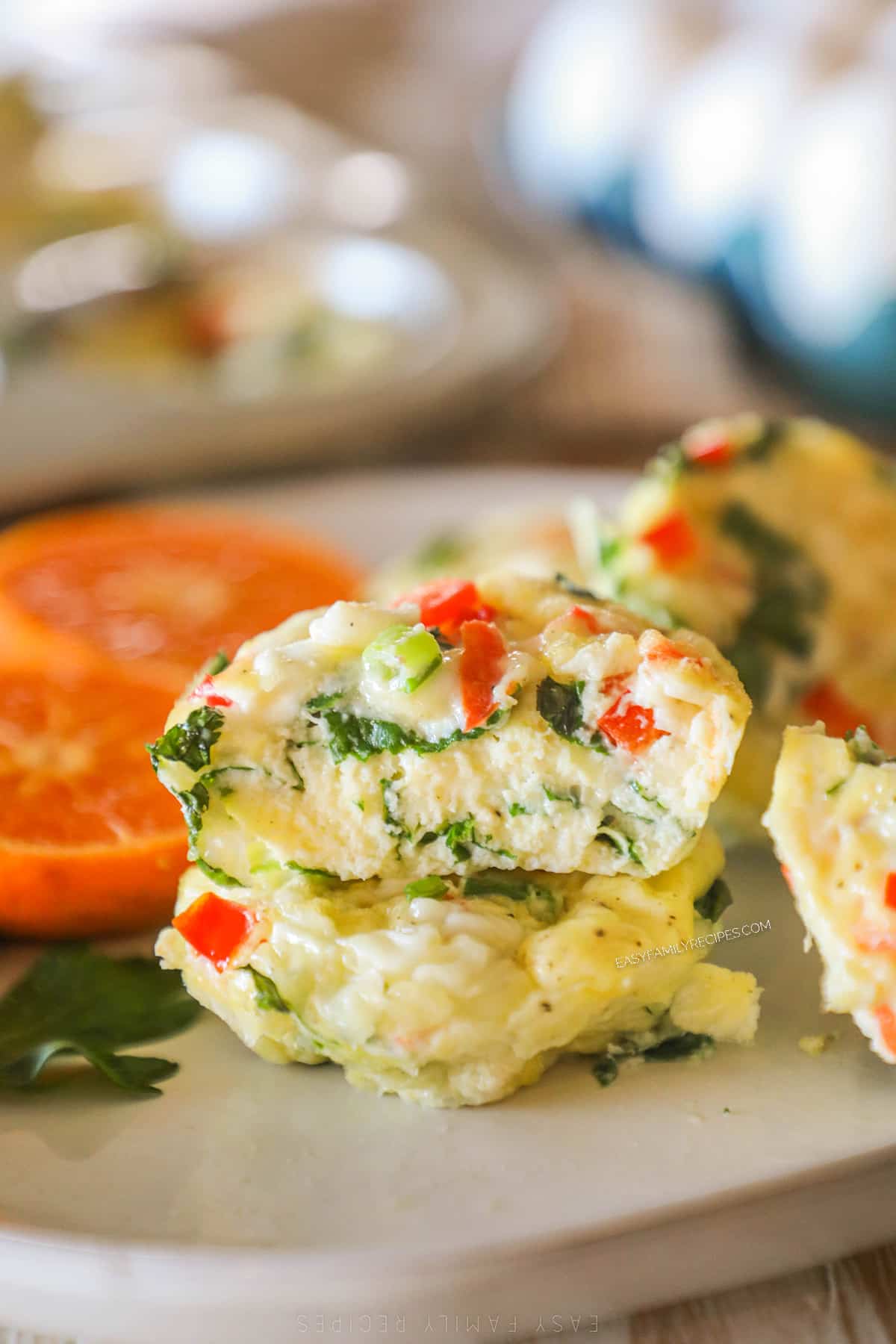 Cottage cheese egg bites on a white plate with sliced tomatoes on the side.