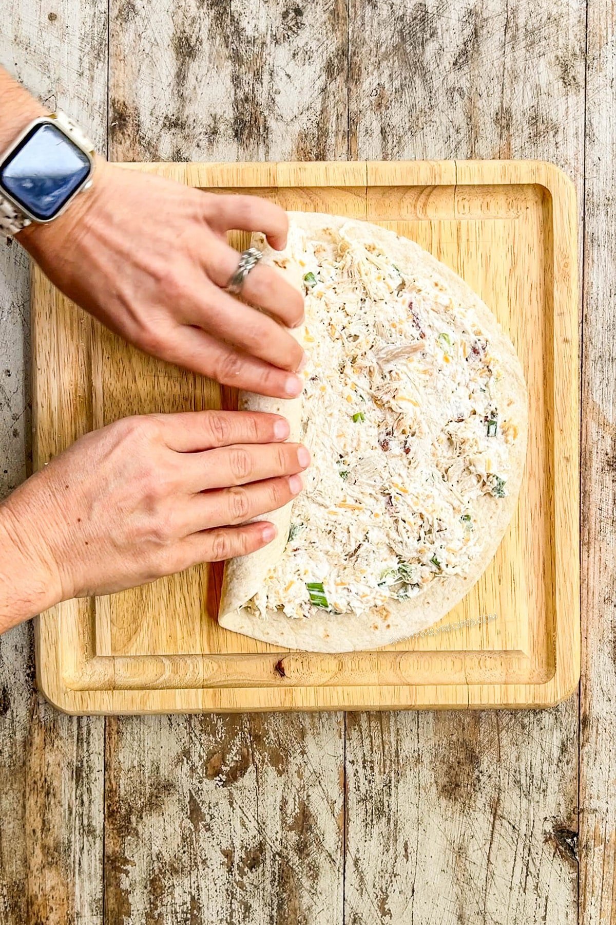 Rolling up the tortilla for chicken bacon ranch pinwheels.