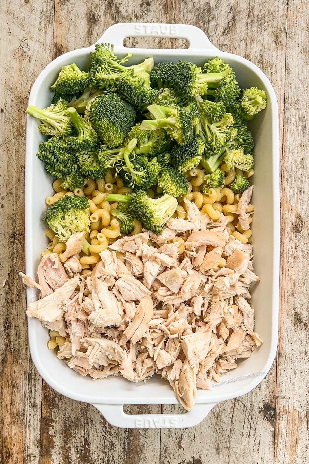 broccoli, pasta, and chicken in a casserole dish.