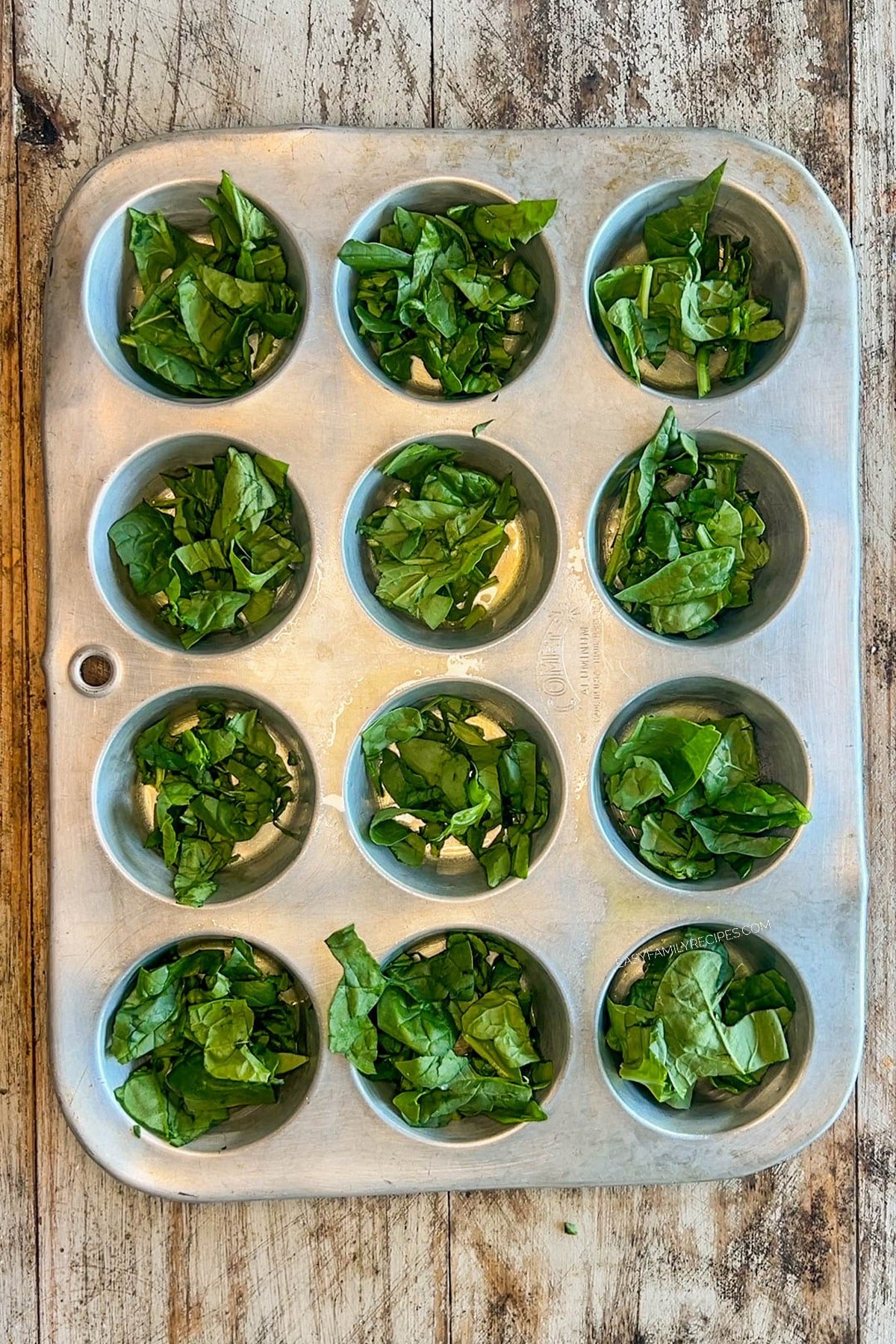 Greens are added to the muffin tin for cottage cheese egg bites.