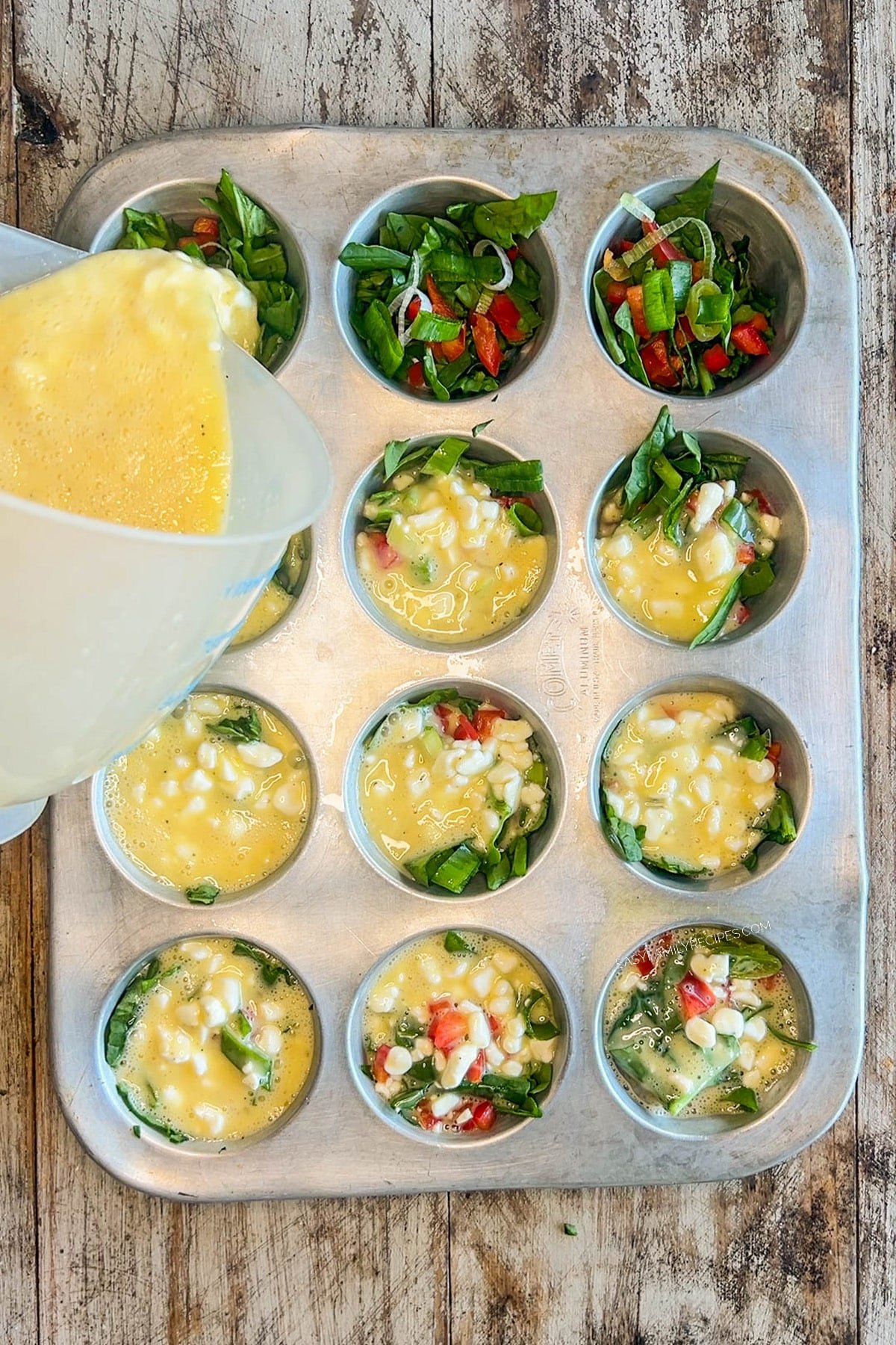 The egg mixture is poured into the muffin tins for cottage cheese egg bites.