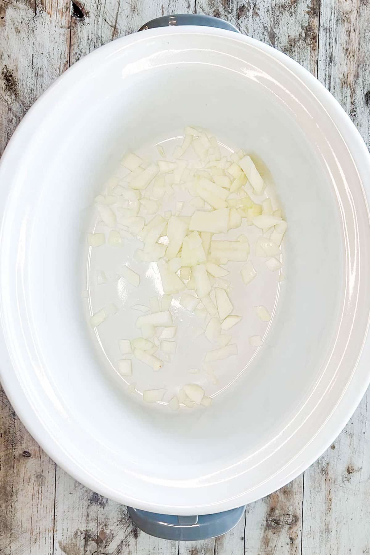 How to make slow cooker chicken and potatoes step 1- Dice onion and add to the crockpot.