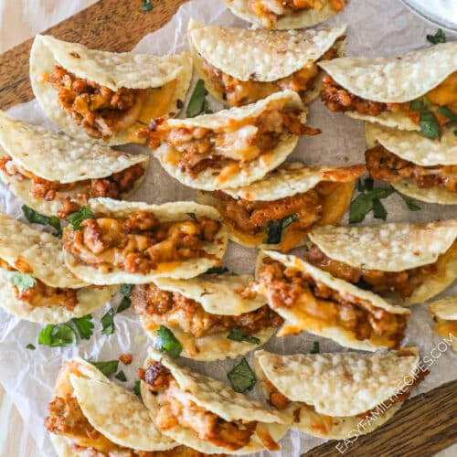 Tiny Tacos on a parchment-lined wooden board.