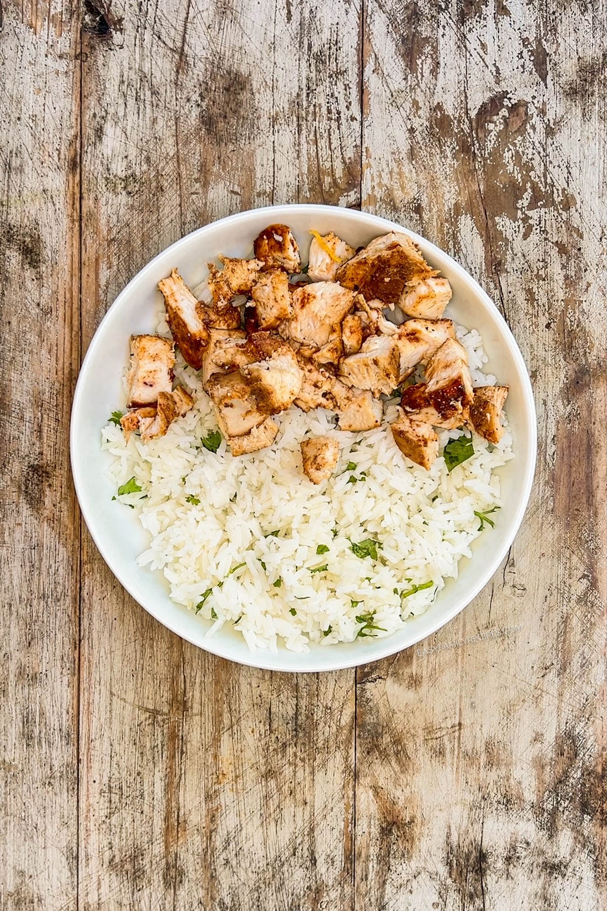 Top view of step 2 in how to make a BBQ chicken bowl: Add the chicken to the bowl.