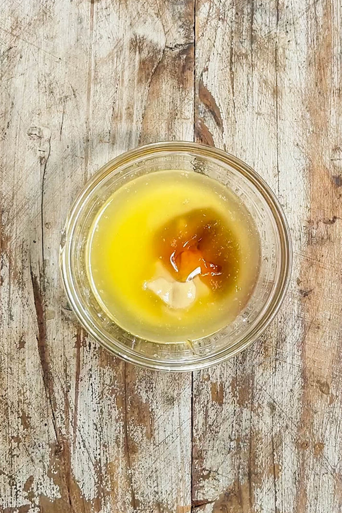 Ingredients for honey dijon butter in a clear glass bowl.