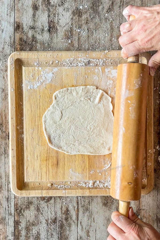 dough being rolled into a tortilla.