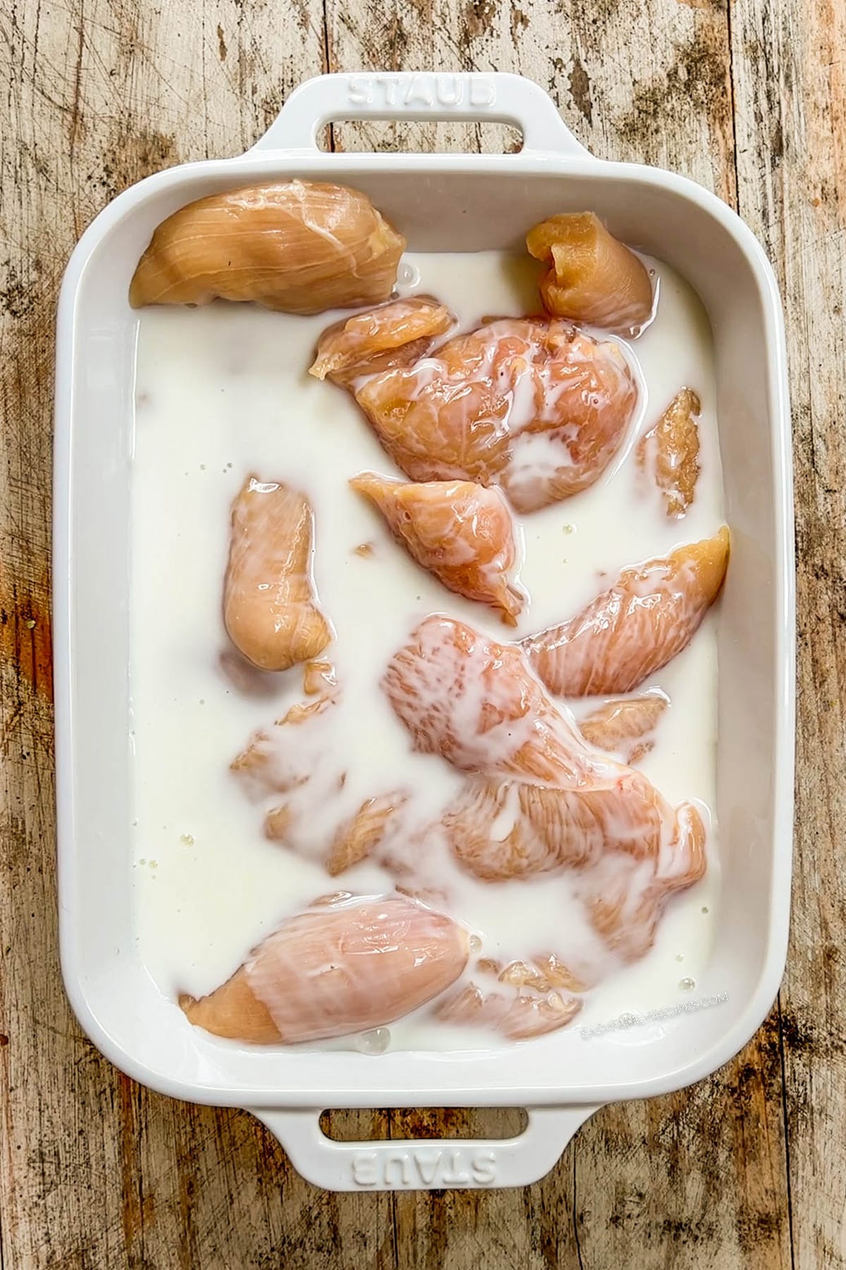 Step 2 for making Hot Honey Chicken Tenders: Drizzle with buttermilk and marinate for a few minutes.