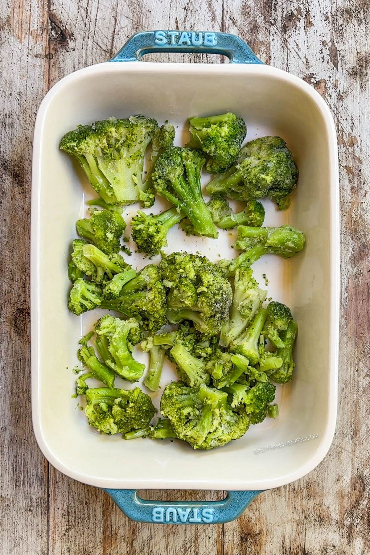 Broccoli at the base of a casserole dish for Nixon chicken.