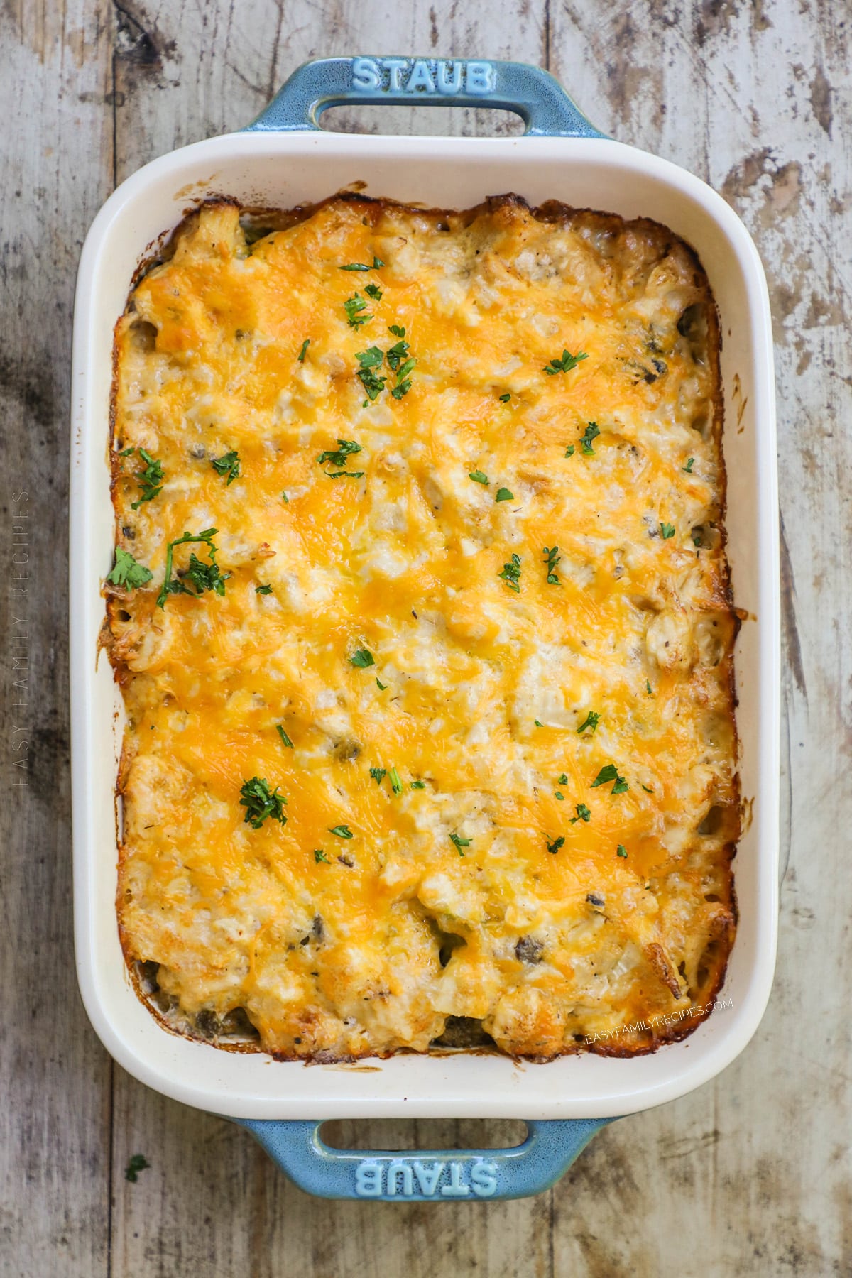 A top view of a teal and white casserole dish full of baked Nixon Chicken.