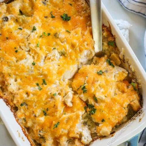 A large spoon scoops out a serving of Nixon Chicken from a white and teal baking dish.