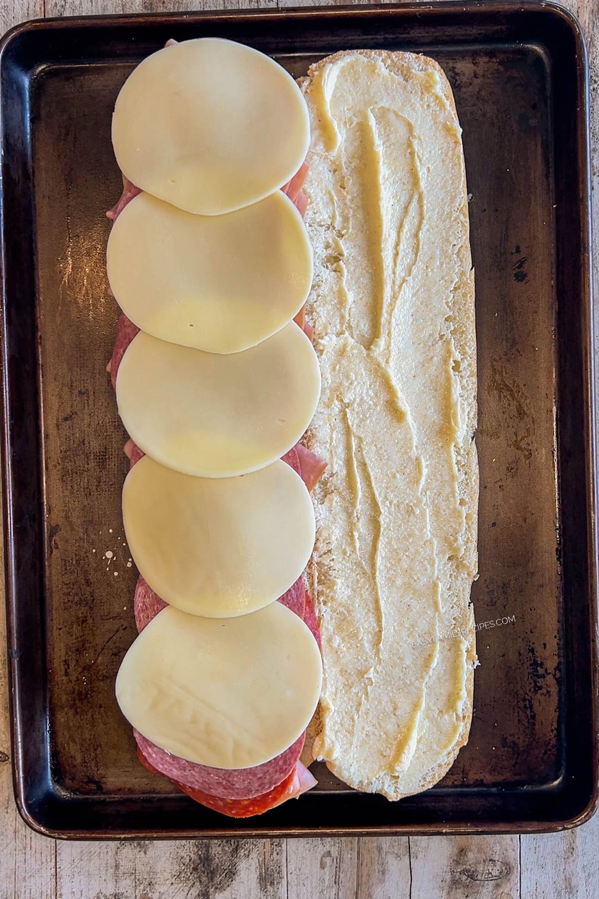 Step 2 for making Italian Grinder Sandwiches - top the meat with the provolone cheese.