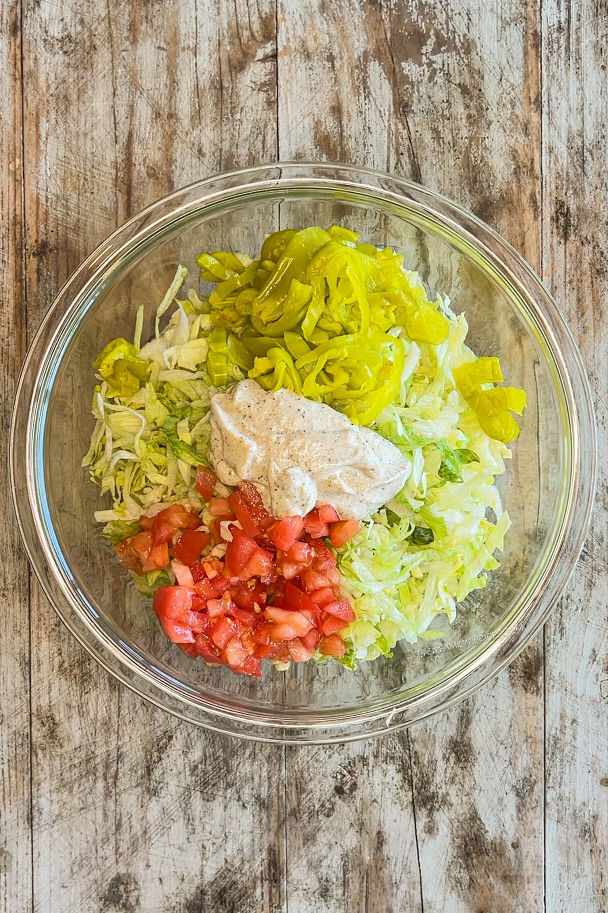 Step 3 for making Italian Grinder Sandwiches - add the salad mix ingredients to a mixing bowl.