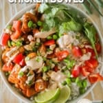 Easy chili crunch chicken bowl assembled in a bowl with dressing drizzled on top.