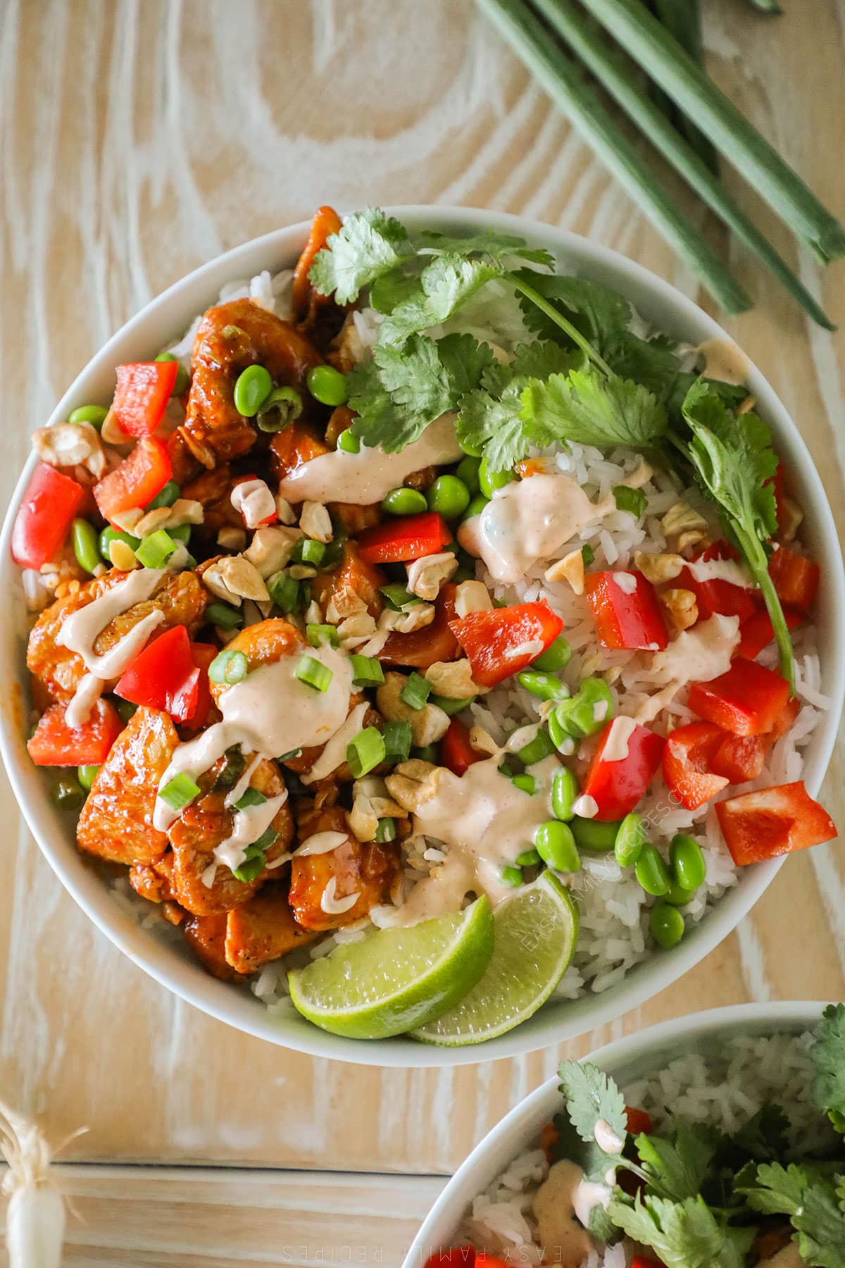 Easy chili crunch chicken bowl assembled in a bowl with dressing drizzled on top.