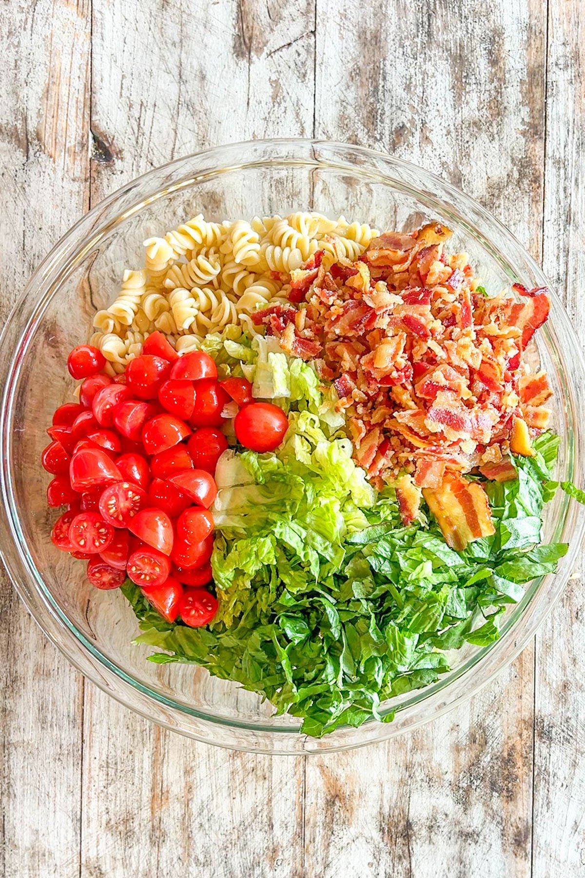 ingredients for pasta salad unmixed in a bowl.