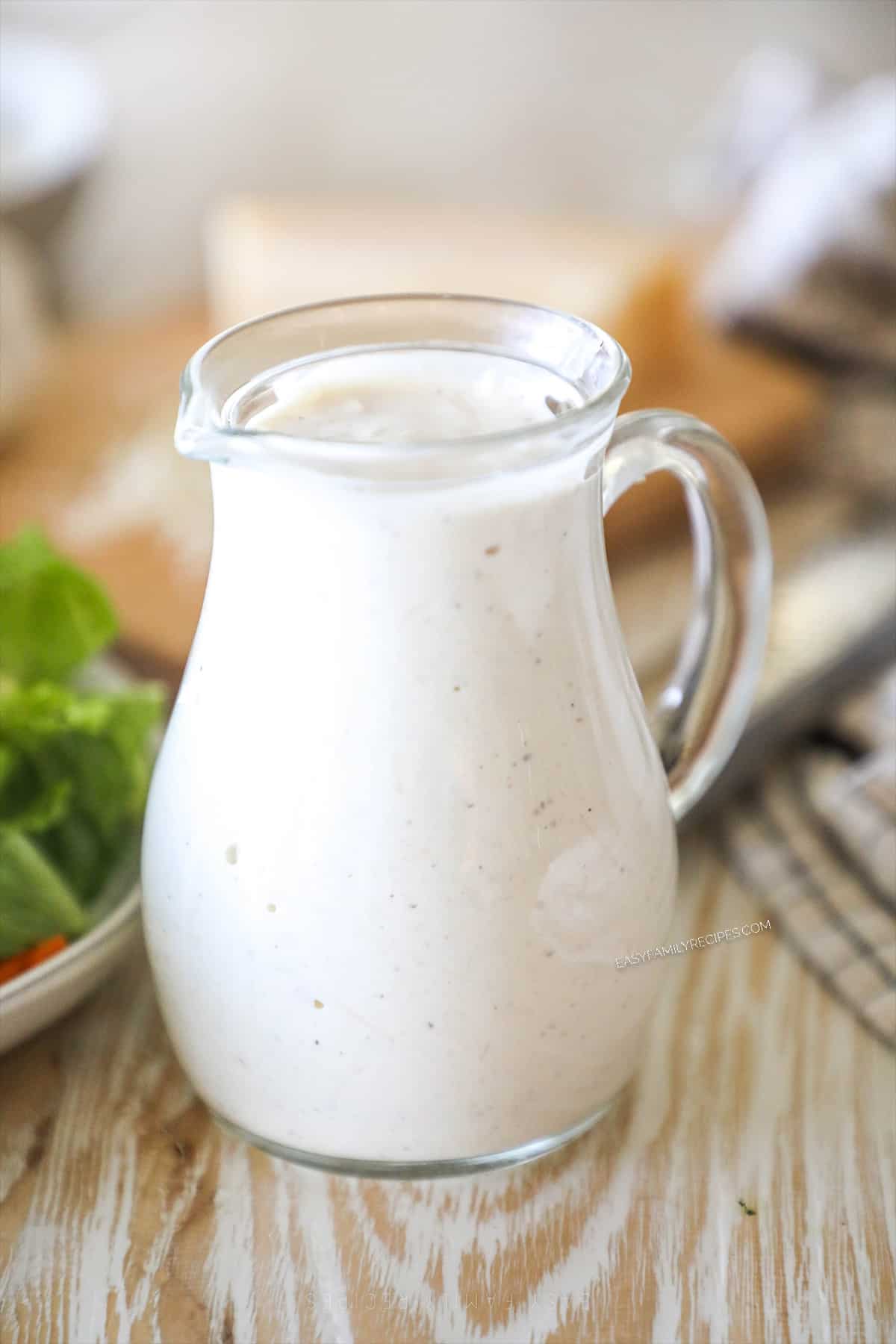 a small pitcher filled with creamy Italian parmesan dressing.
