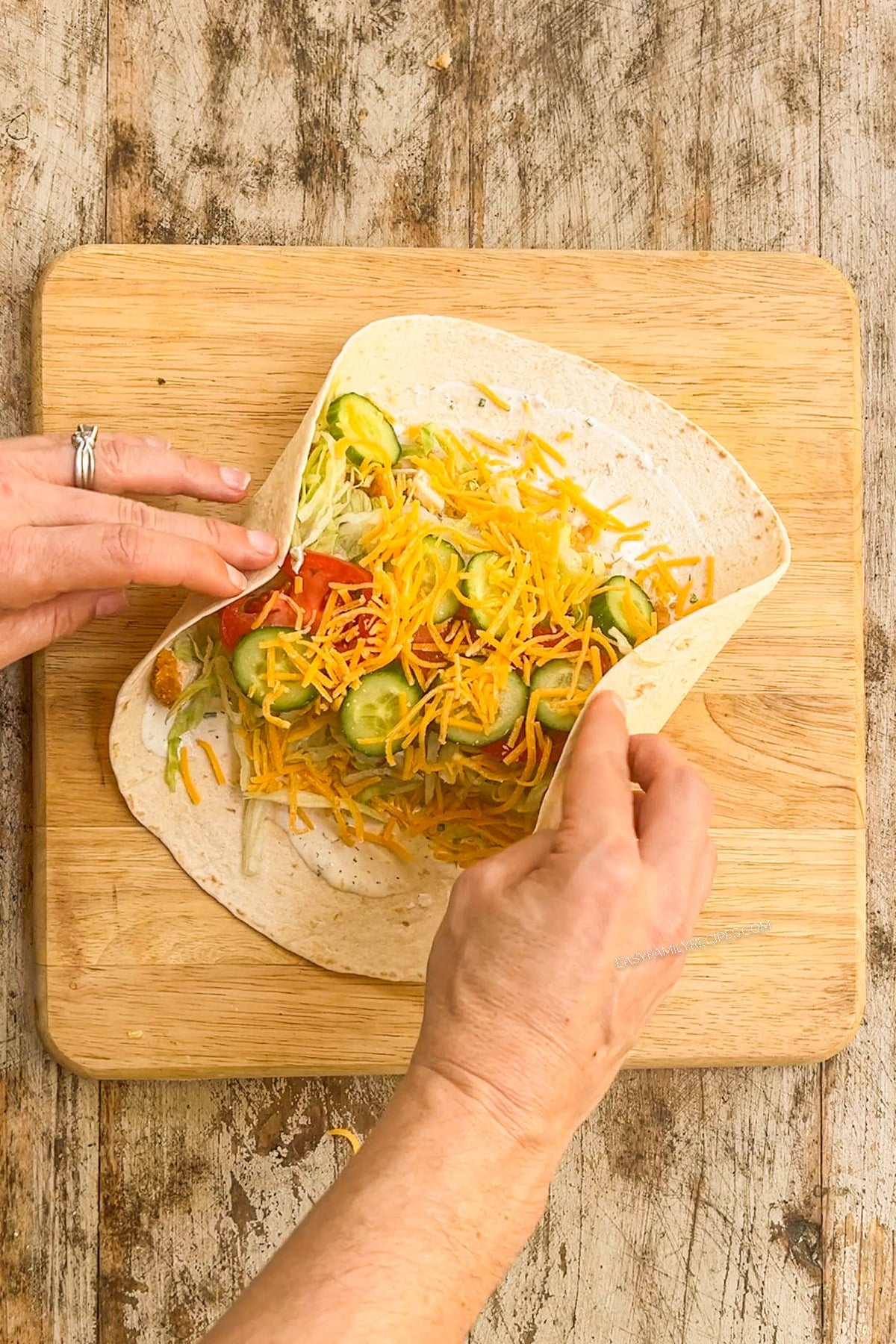 Step three for making chicken tender wraps: Add cheese and roll up.