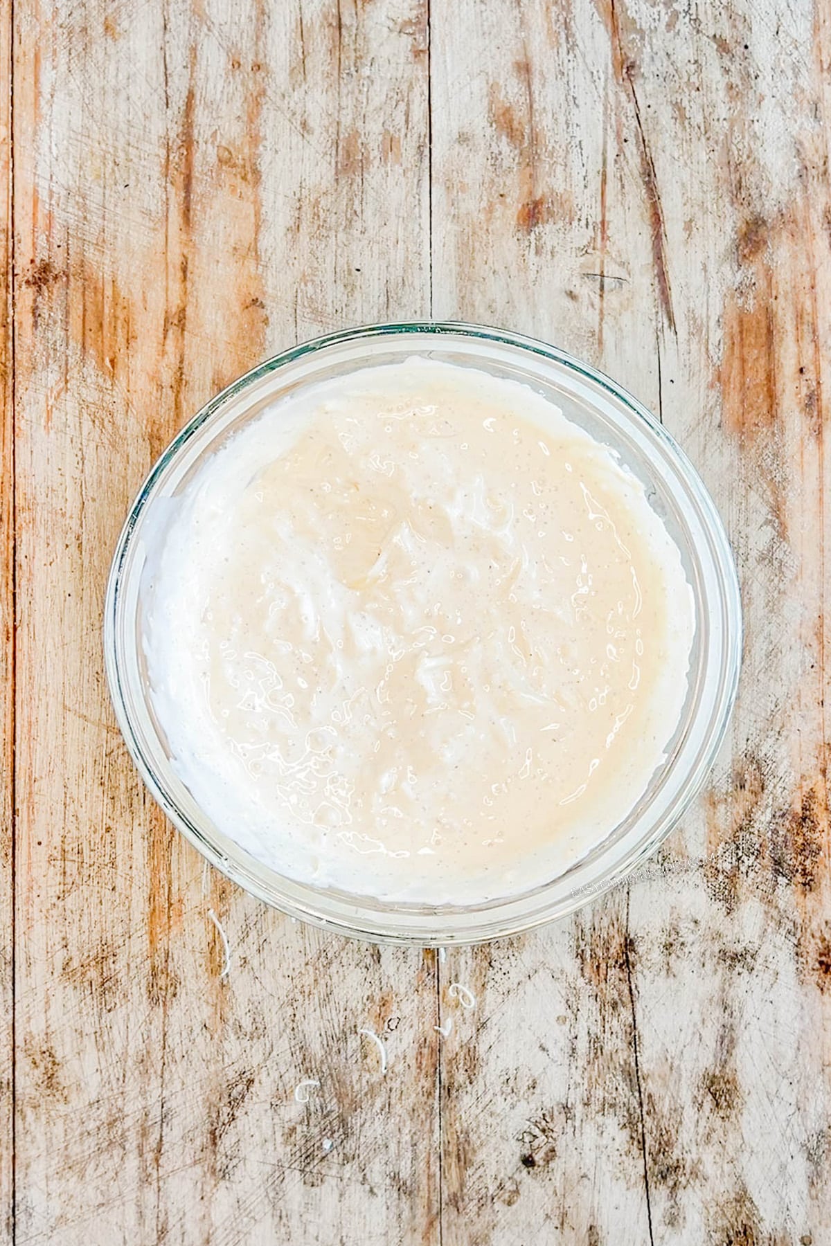 above image of a mixing bowl with finished creamy Italian parmesan dressing.