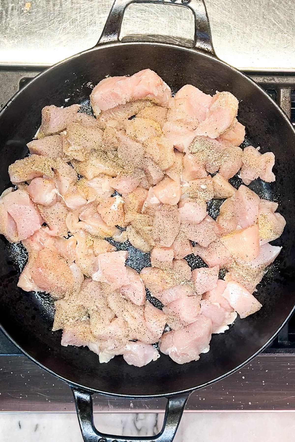 Step one for making lemon chicken orzo: Saute the chicken pieces in a skillet.