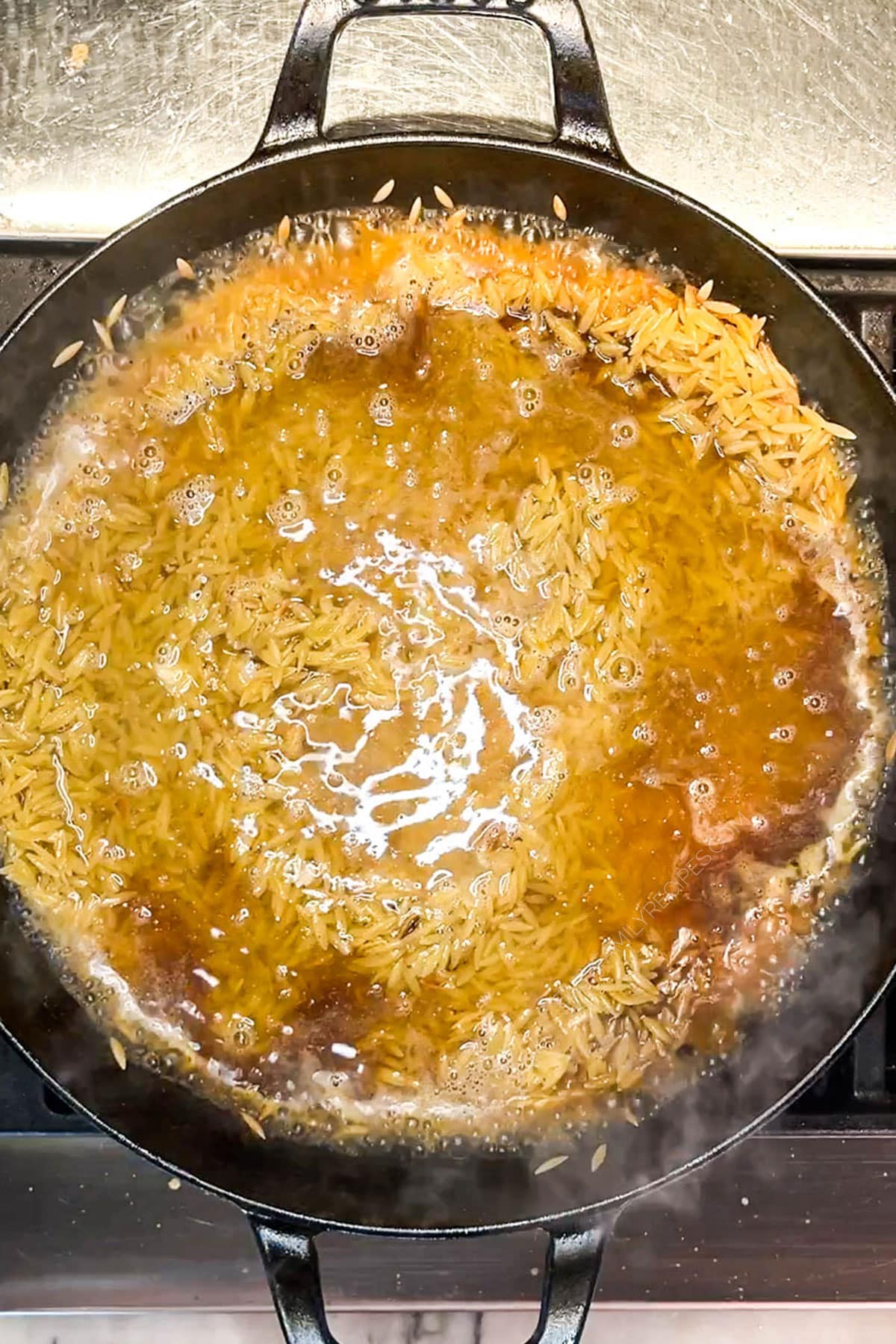 Step 3 for how to make creamy lemon orzo with chicken - add the broth and cream.