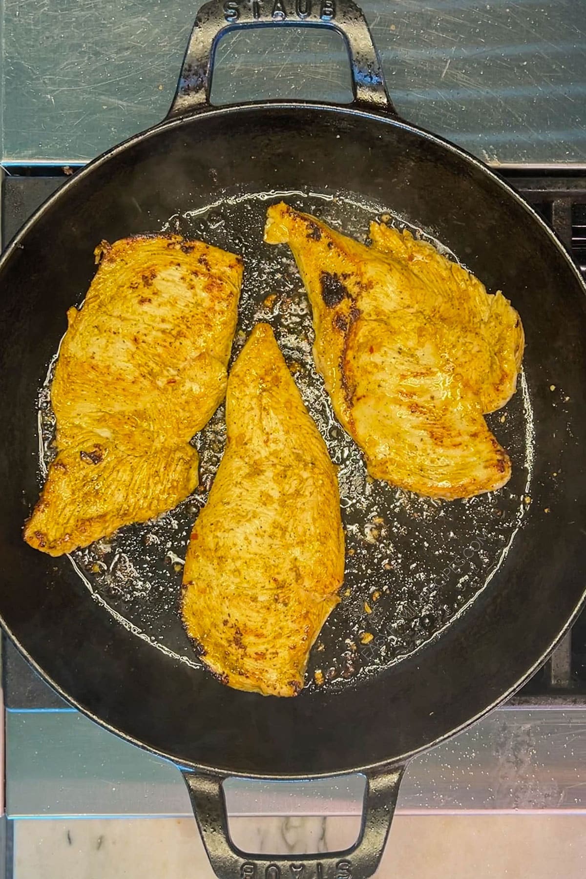 Top view of chicken in a black skillet for chicken fajita tacos.