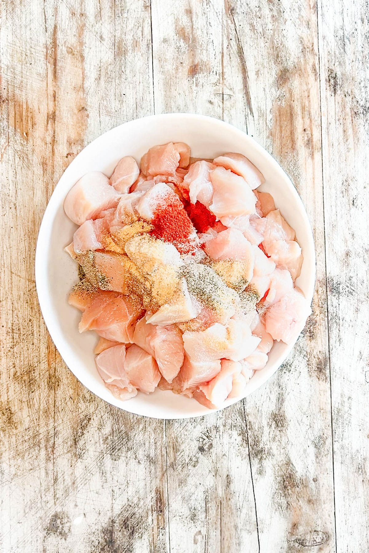 Mixing the chicken with seasoning for Honey BBQ Chicken Bites.