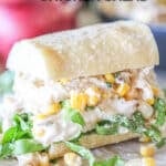 Street Corn Chicken Salad in a bun on a wooden board. The text reads, "Mexican Street Corn Chicken Salad"