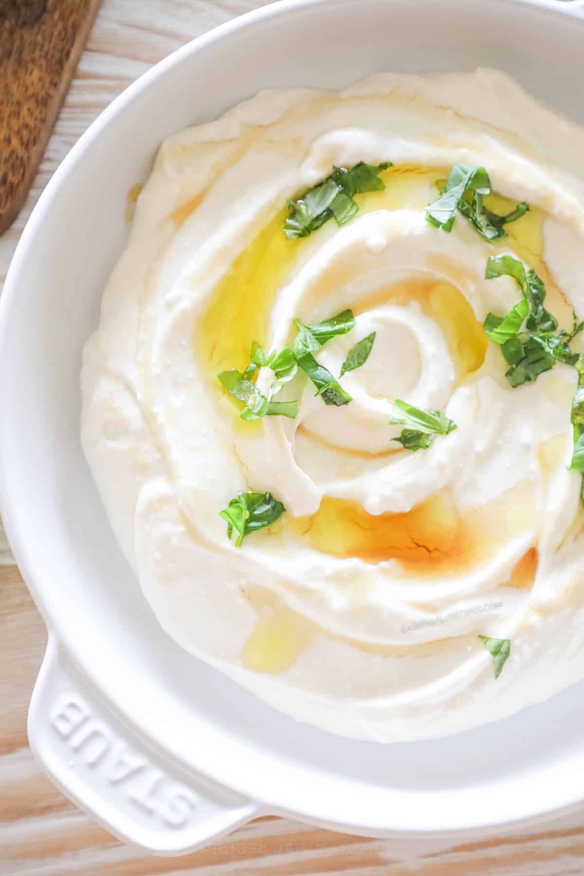 above image of whipped honey feta topped with basil and honey.