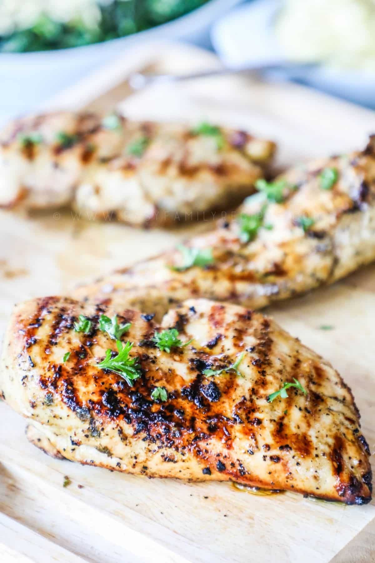greek marinated grilled chicken breast on a cutting board