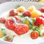 side view of honey whipped feta dip topped with roasted tomatoes.
