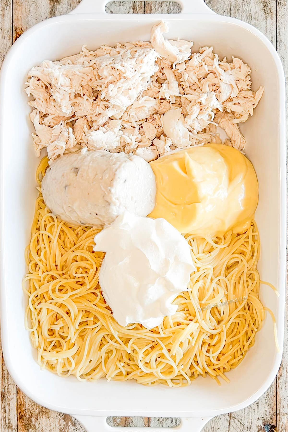 Step two for how to make baked chicken spaghetti: Add soups and sour cream.