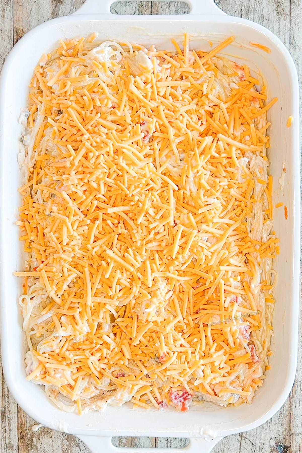 Step five for how to make baked chicken spaghetti: Add cheddar cheese