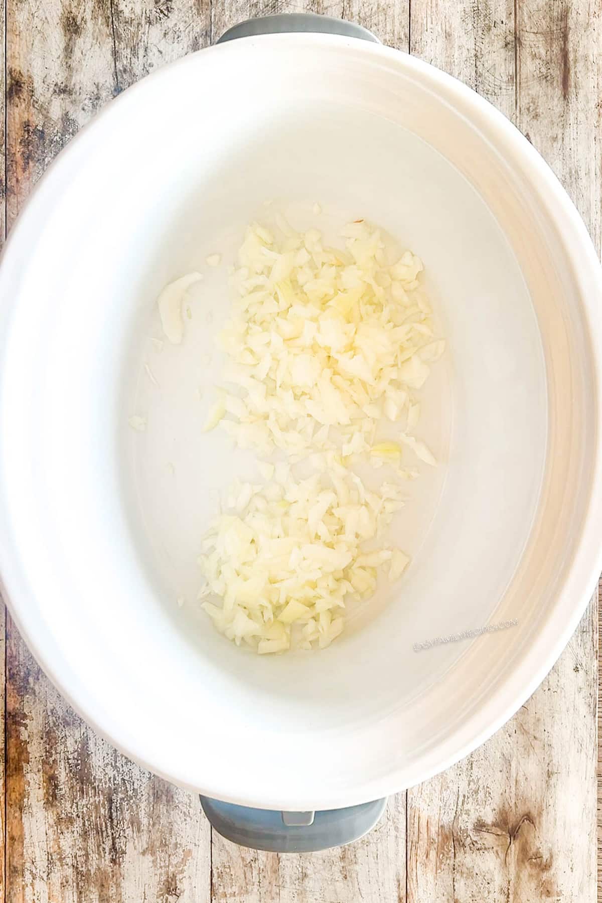 Step one for making Crockpot Pork Chile Verde: Add the onions to the Crock.