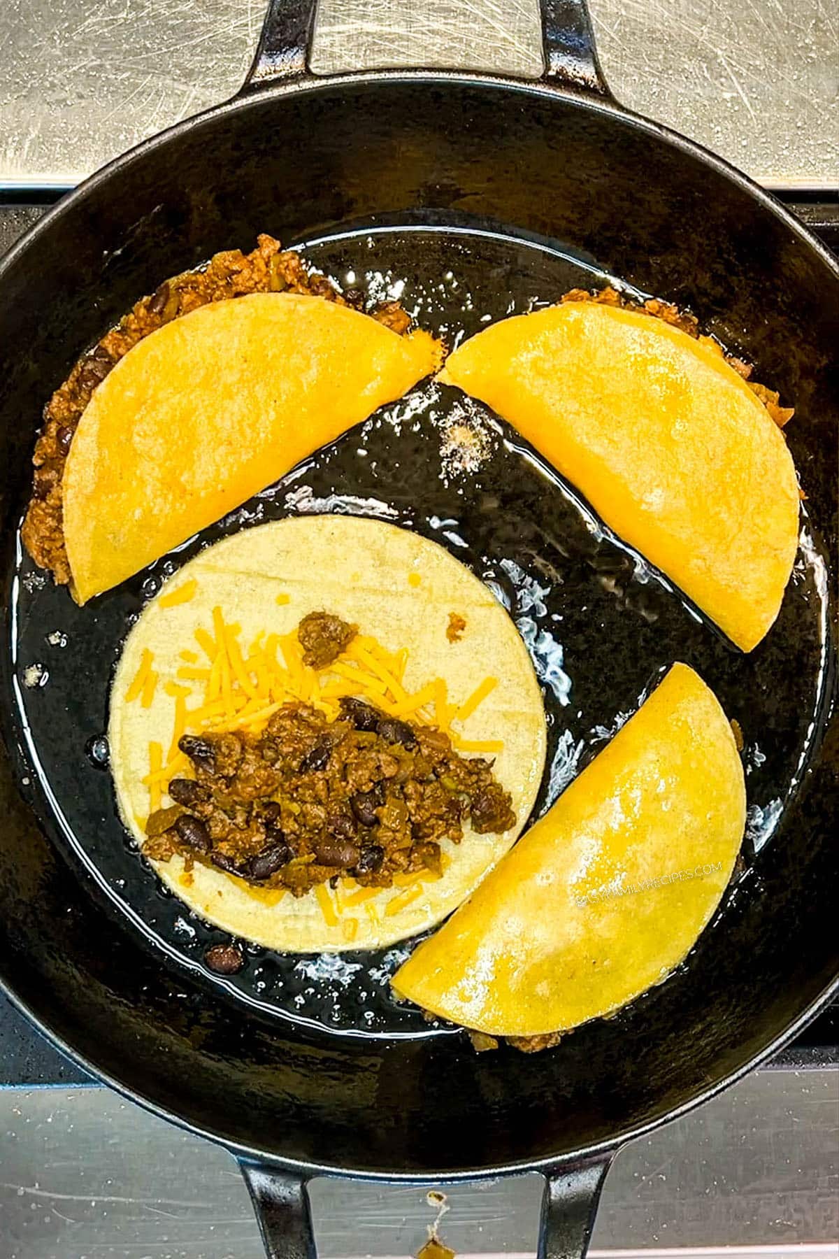 tacos being assembled and fried in a skillet.