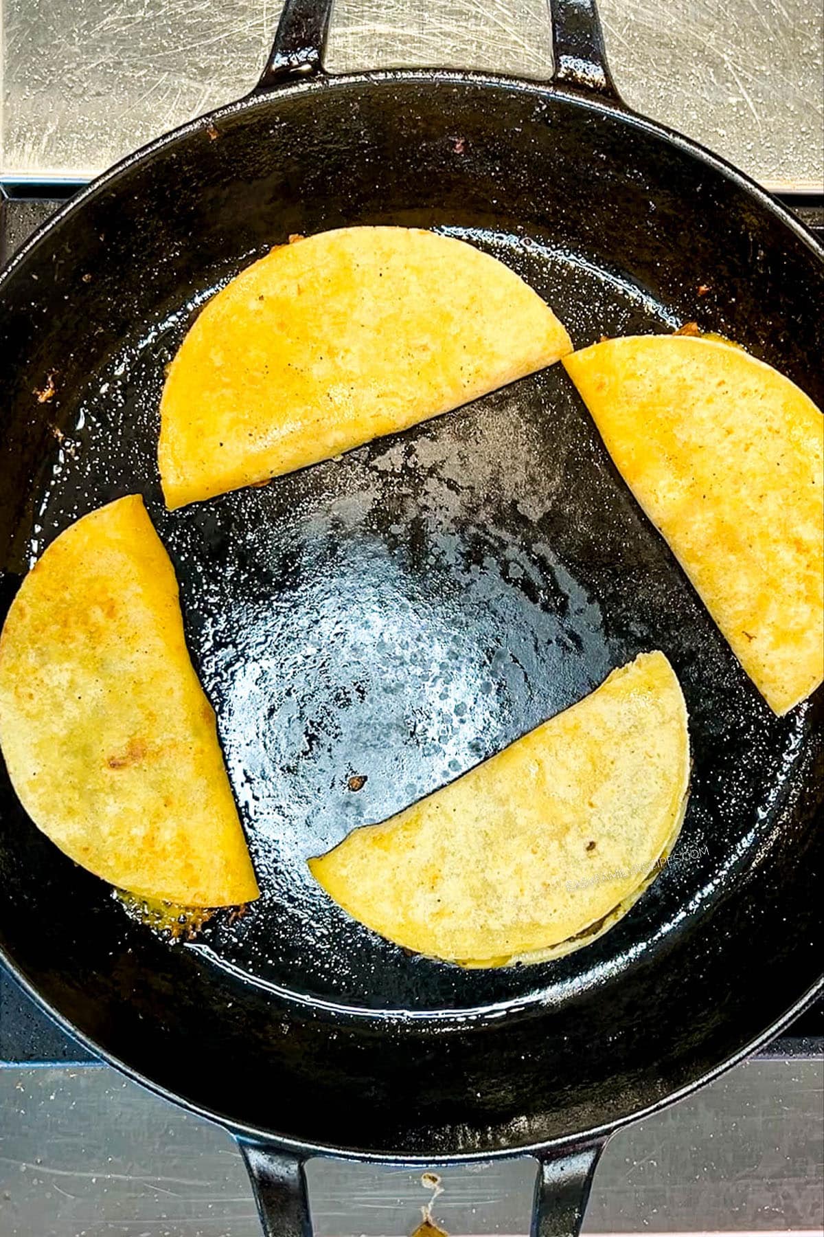 fried tacos in a skillet.